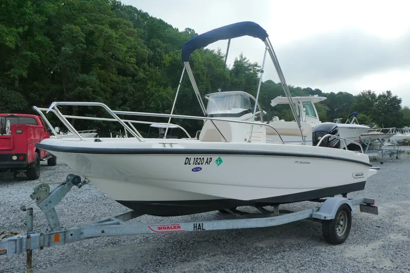 Slide: The Image of 2017 Boston Whaler 170 Dauntless boat on trailer, parked outdoors. - 1