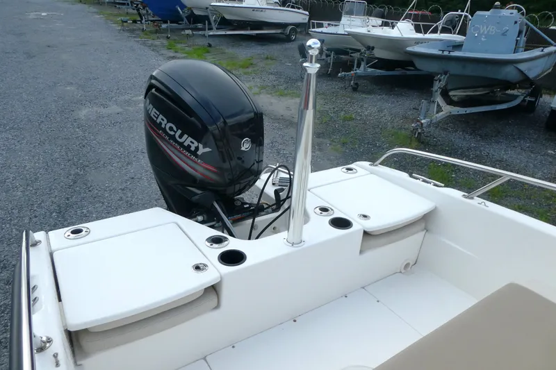 Slide: The Image of 2017 Boston Whaler 170 Dauntless boat with Mercury outboard engine, docked on gravel. - 4