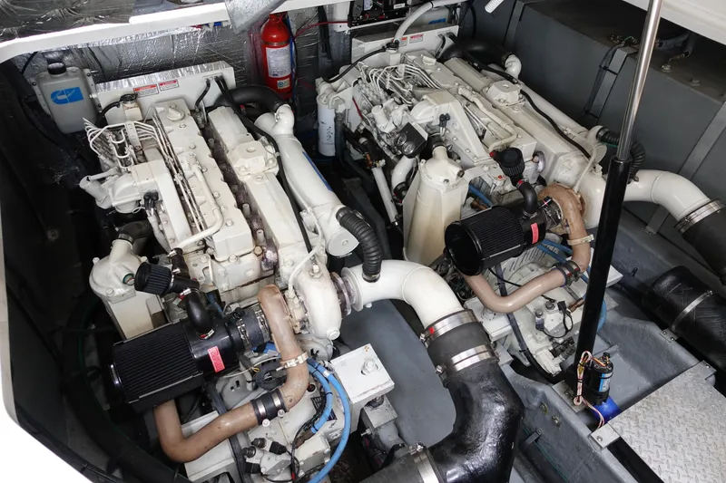 Slide: The Image of Engine room of a 2001 Sea Ray 410 Express Cruiser with dual engines and fire extinguisher. - 26
