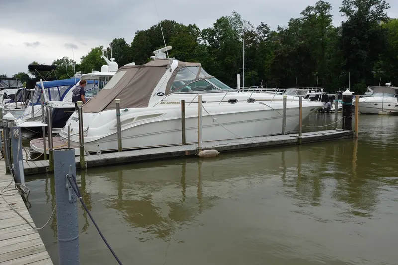 The Image of 2001 Sea Ray 410 Express Cruiser docked at marina, surrounded by other boats. - 0