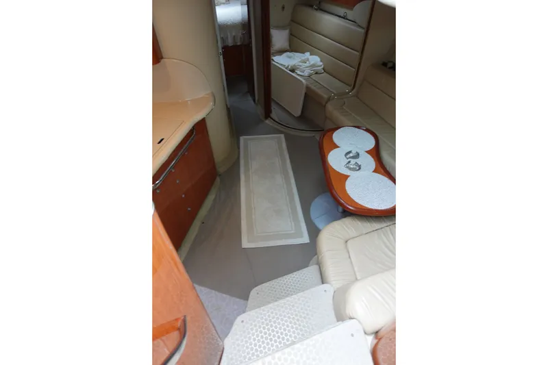 Slide: The Image of Interior of 2001 Sea Ray 410 Express Cruiser with beige seating and wooden table. - 13