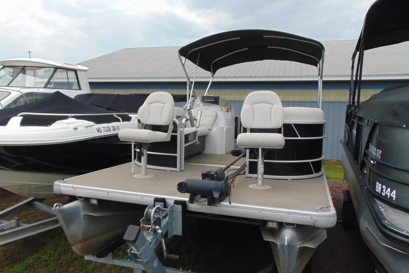 The Image of 2017 Godfrey Sweetwater 2286 BF pontoon boat with canopy, docked alongside other boats. - 1