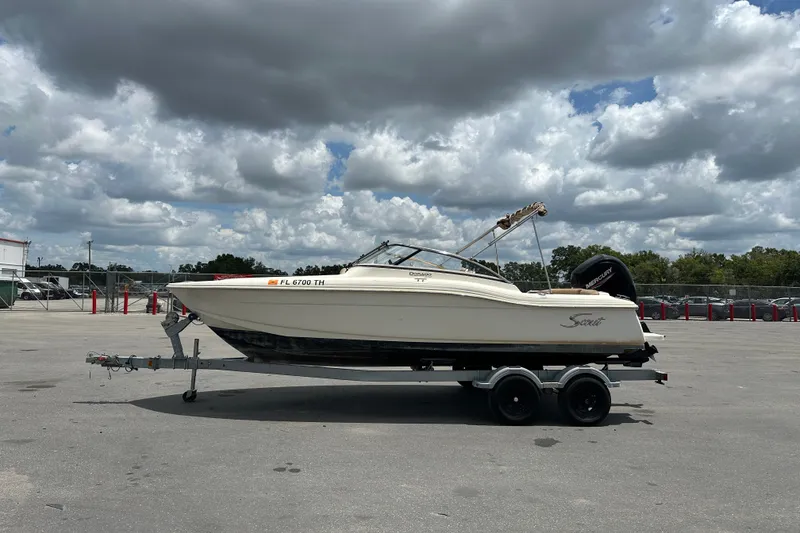 Slide: The Image of 2023 Scout 210 Dorado boat on trailer under cloudy sky. - 1