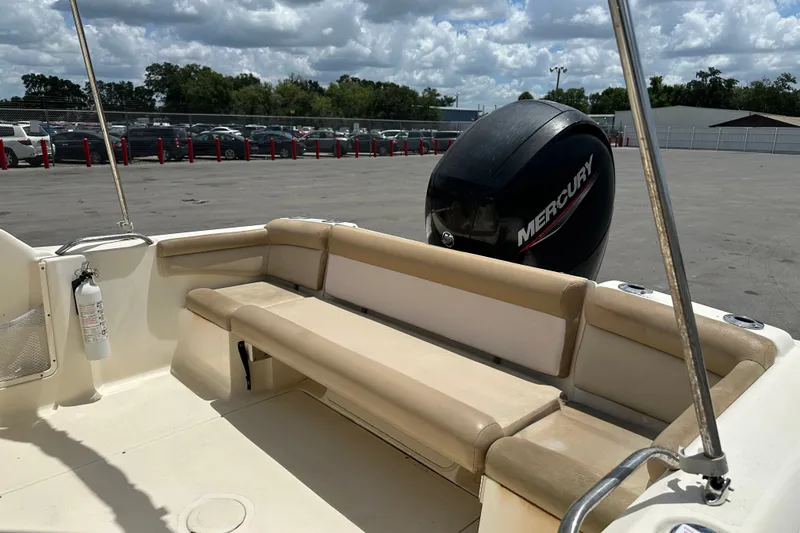 Slide: The Image of 2023 Scout 210 Dorado boat interior with Mercury engine, parked outdoors. - 13