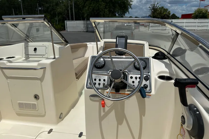 Slide: The Image of 2023 Scout 210 Dorado boat cockpit with steering wheel and control panel. - 10