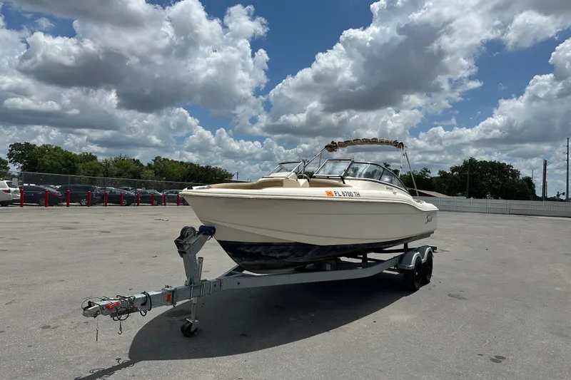 Slide: The Image of 2023 Scout 210 Dorado boat on trailer under cloudy sky in parking lot. - 3