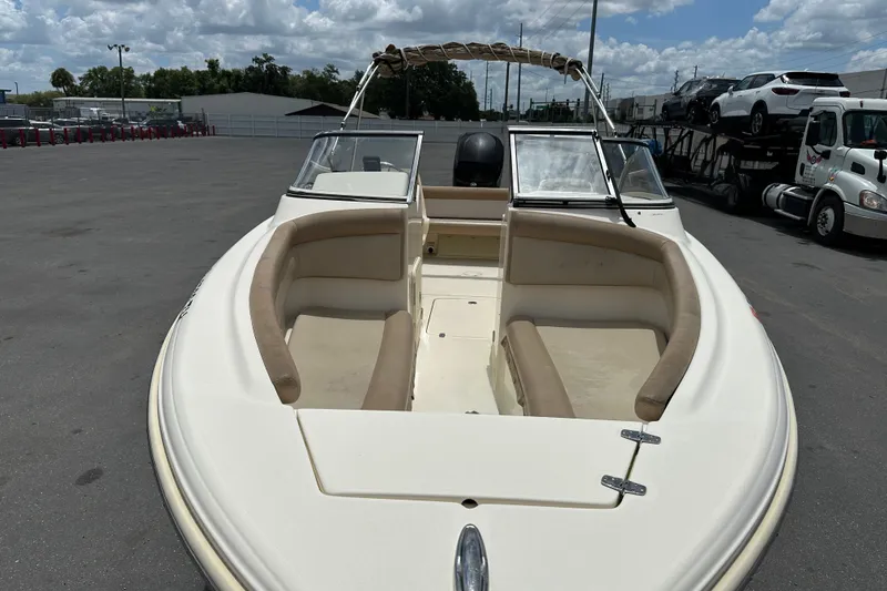 Slide: The Image of 2023 Scout 210 Dorado boat with beige seating, parked outdoors under cloudy sky. - 8