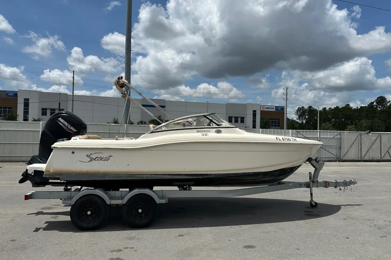 The Image of 2023 Scout 210 Dorado boat on trailer under cloudy sky. - 0