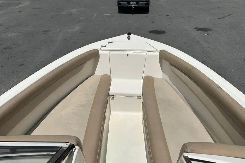 Slide: The Image of 2023 Scout 210 Dorado boat interior with beige seating, parked on asphalt. - 15