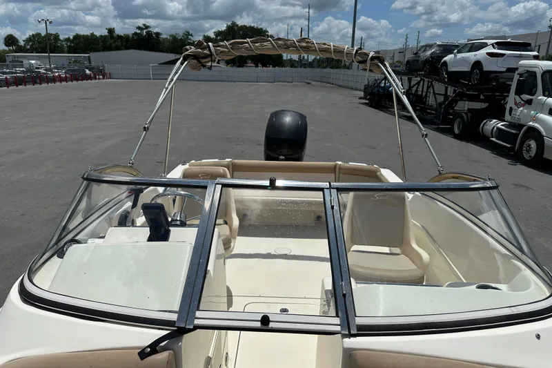 Slide: The Image of 2023 Scout 210 Dorado boat with open deck and windshield, parked outdoors. - 16