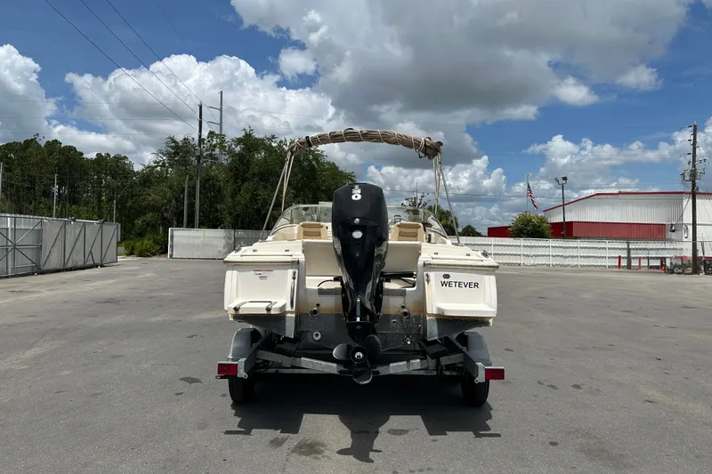 Slide: The Image of 2023 Scout 210 Dorado boat on trailer, parked outdoors under cloudy sky. - 6
