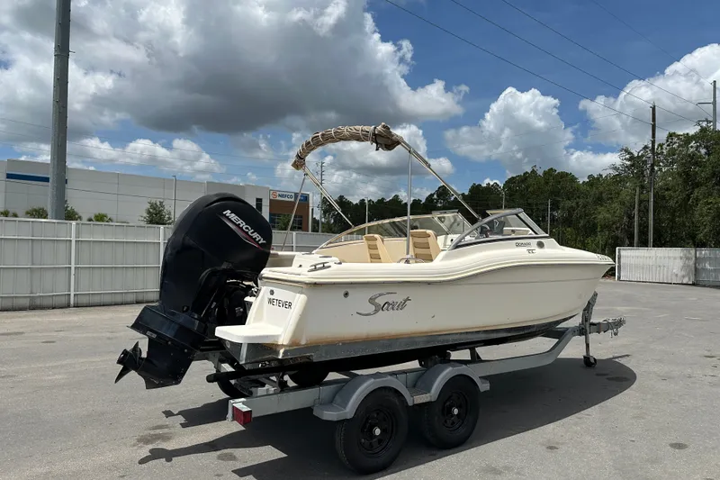 Slide: The Image of 2023 Scout 210 Dorado boat on trailer with Mercury outboard motor, parked outdoors. - 4