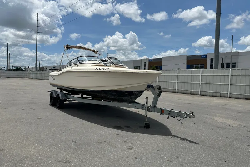 Slide: The Image of 2023 Scout 210 Dorado boat on trailer under cloudy sky in parking lot. - 5