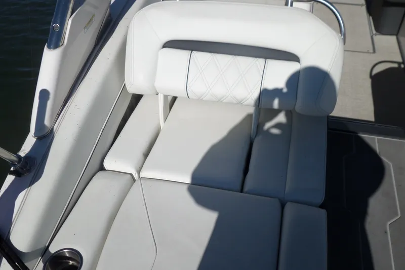 Slide: The Image of White leather seating on a 2020 Regal LS6 boat, with shadow and cup holder visible. - 33
