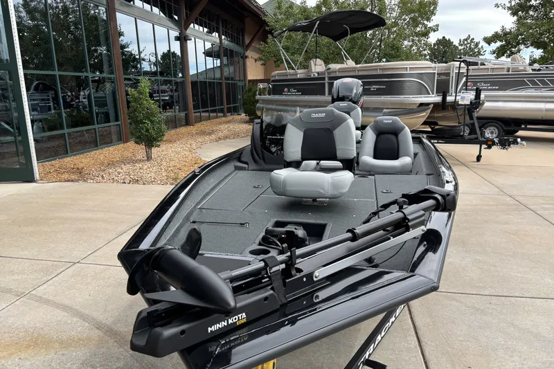 Slide: The Image of 2027 Tracker Pro Team 190 boat with Minn Kota trolling motor, parked outdoors. - 15