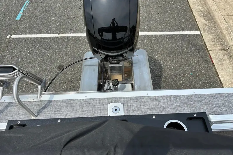 Slide: The Image of 2027 Sun Tracker SportFish 22 DLX boat engine and deck, parked on asphalt. - 17