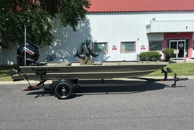 The Image of 2027 Tracker Grizzly 1860 CC boat on trailer, parked outside a building. - 0