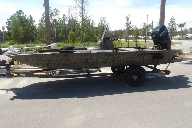 The Image of 2027 Tracker Grizzly 1860 CC boat on trailer, parked outdoors. - 1