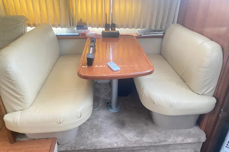 Slide: The Image of Interior of 2006 Carver 41 Cockpit Motor Yacht with beige seating and wooden table. - 14