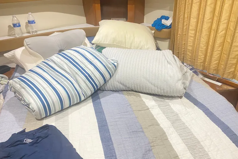 Slide: The Image of Cozy bedroom in 2006 Carver 41 Cockpit Motor Yacht with striped bedding and pillows. - 17