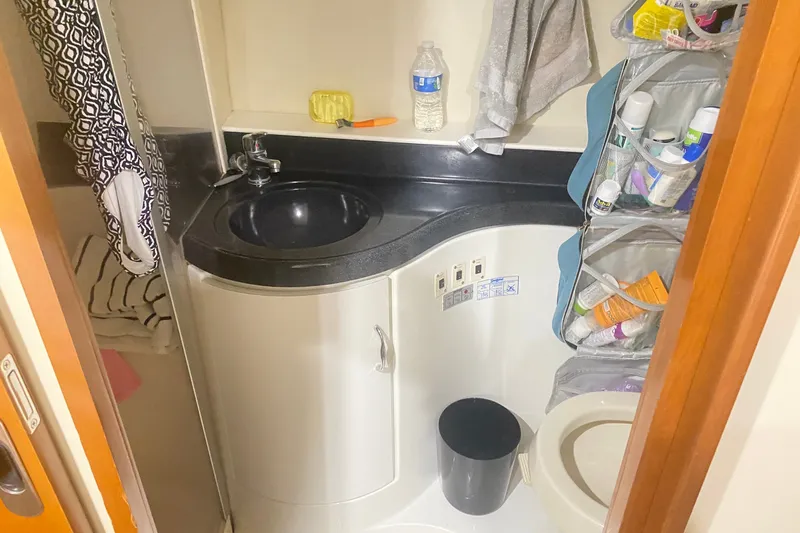 Slide: The Image of Compact bathroom in a 2006 Carver 41 Cockpit Motor Yacht, featuring sink and storage. - 15