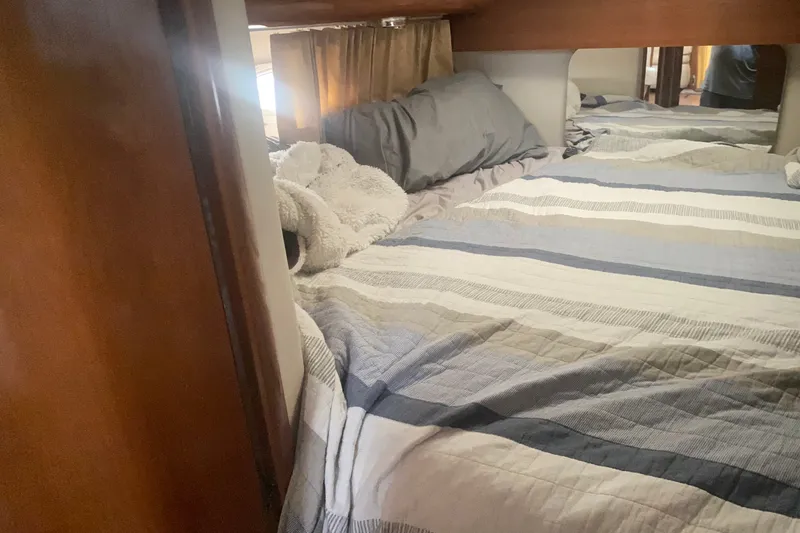 Slide: The Image of Cozy bedroom interior of 2006 Carver 41 Cockpit Motor Yacht with striped bedding. - 16