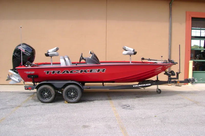 The Image of 2027 Tracker Pro Team 195 boat on trailer, red exterior, parked outdoors. - 0