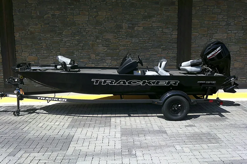The Image of 2027 Tracker Pro 170 boat on trailer, parked on brick pavement, with Mercury outboard motor. - 0
