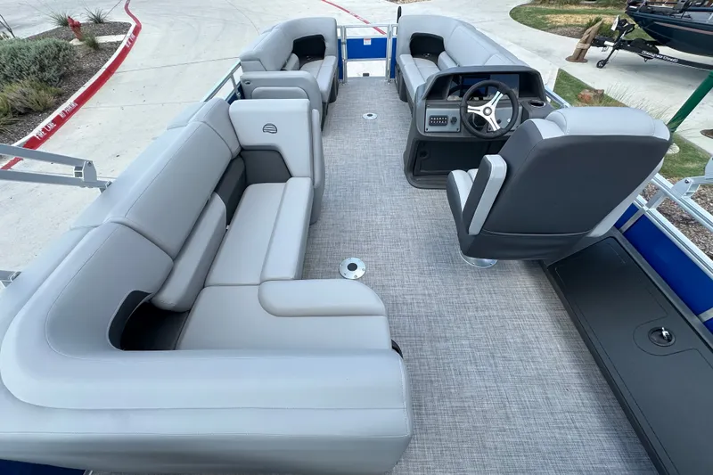 Slide: The Image of 2027 Sun Tracker SportFish 22 DLX pontoon boat interior with gray seating and steering console. - 19