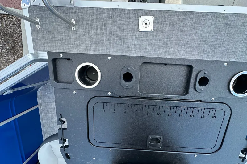 Slide: The Image of Control panel of 2027 Sun Tracker SportFish 22 DLX boat with cup holders and ruler. - 21