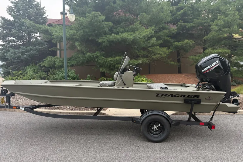 The Image of 2027 Tracker Grizzly 1860 CC boat on trailer, parked near trees. - 0