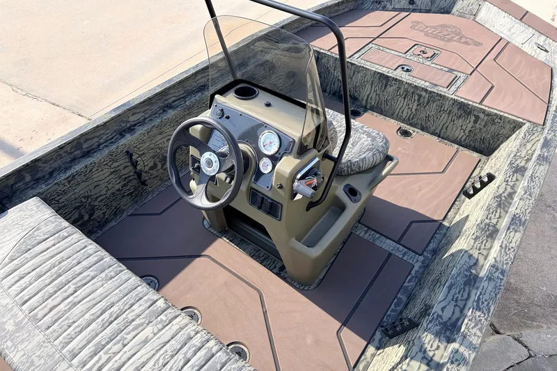 Slide: The Image of 2027 Tracker Grizzly 1860 CC boat interior with steering console and camouflage design. - 22