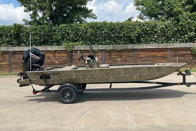 The Image of 2027 Tracker Grizzly 1860 CC boat on trailer, outdoors with greenery background. - 0