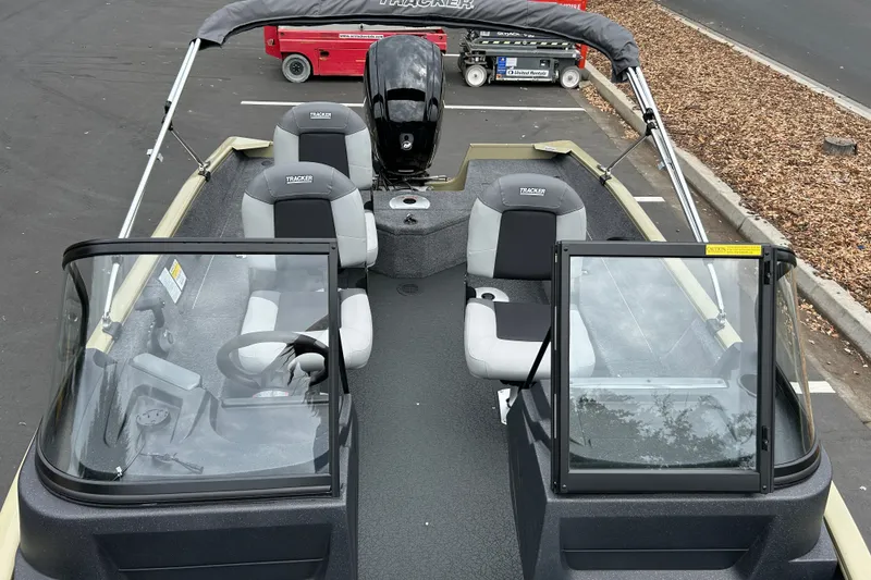 Slide: The Image of 2027 Tracker Pro Guide V-16 WT boat with seating and windshield, parked outdoors. - 16