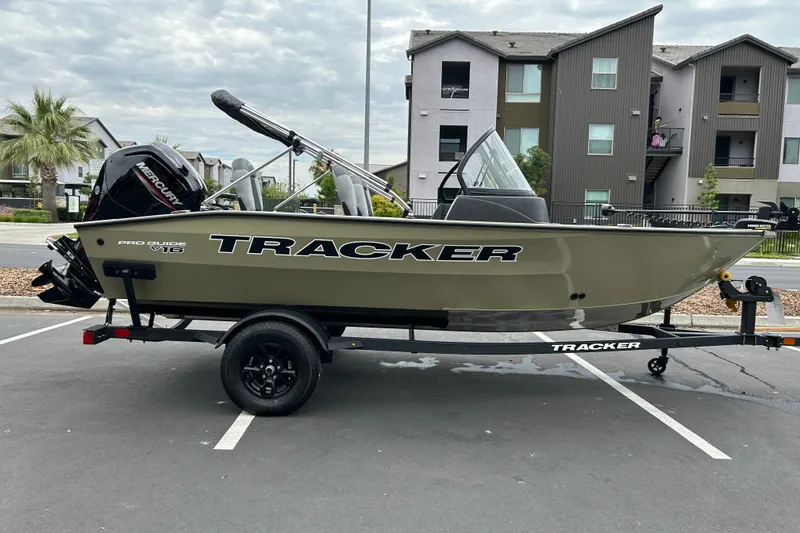 The Image of 2027 Tracker Pro Guide V-16 WT boat on trailer in parking lot. - 0