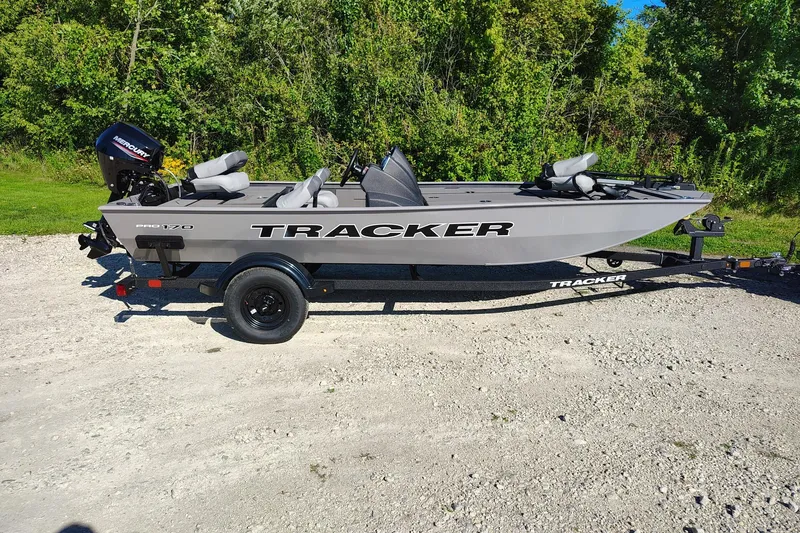 The Image of 2027 Tracker Pro 170 boat on trailer, parked on gravel with lush green background. - 0