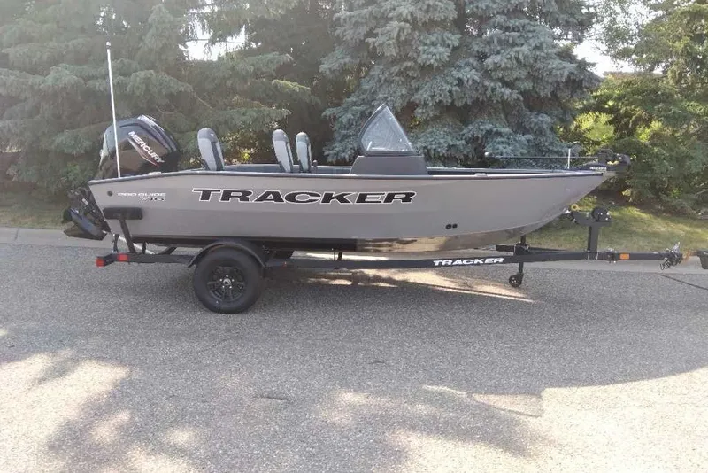 The Image of 2027 Tracker Pro Guide V-16 WT boat on trailer, parked outdoors. - 0