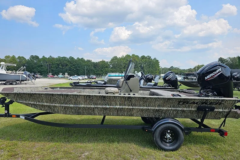 The Image of 2027 Tracker Grizzly 1860 CC boat on trailer, parked outdoors under a blue sky. - 1