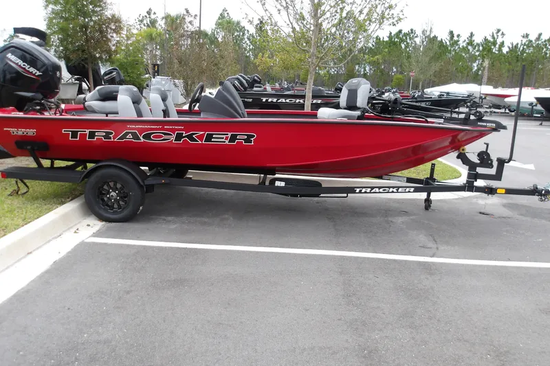 The Image of Red 2027 Tracker Pro Team 190 boat on trailer in parking lot. - 1