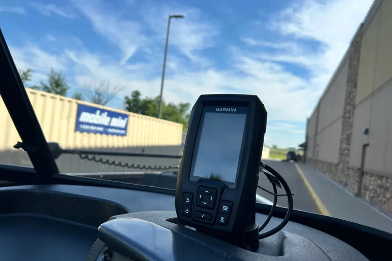 Slide: The Image of Garmin GPS device on 2027 Tracker Pro Guide V-16 WT dashboard, outdoor setting. - 14