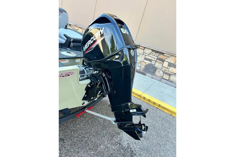 Slide: The Image of 2027 Tracker Pro Guide V-16 WT with Mercury 60 outboard motor, parked on pavement. - 47