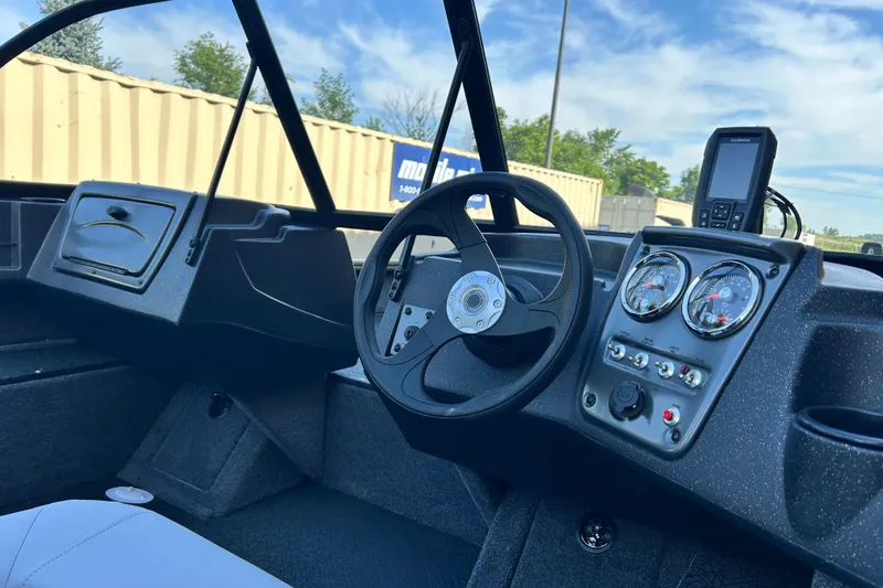 Slide: The Image of Interior view of 2027 Tracker Pro Guide V-16 WT boat dashboard with steering wheel and gauges. - 13
