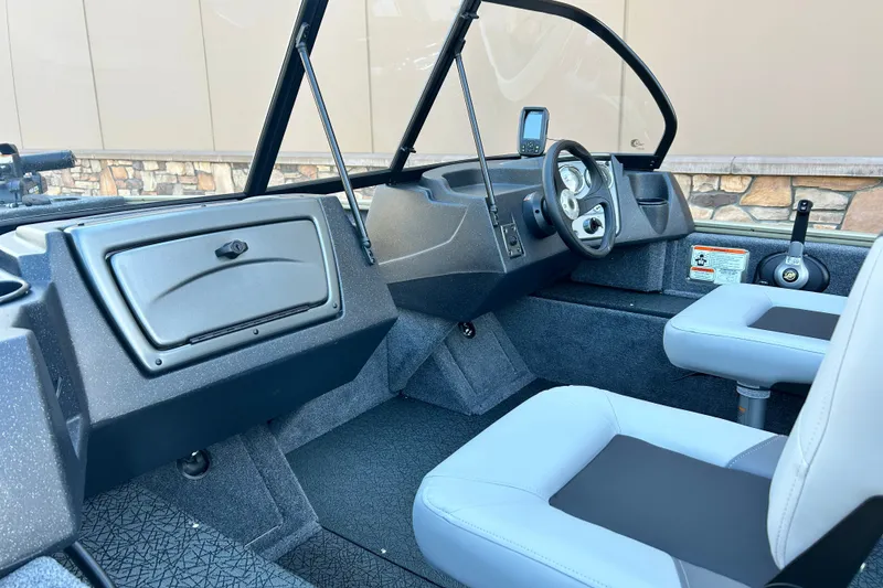 Slide: The Image of 2027 Tracker Pro Guide V-16 WT boat interior with steering wheel and seating. - 46