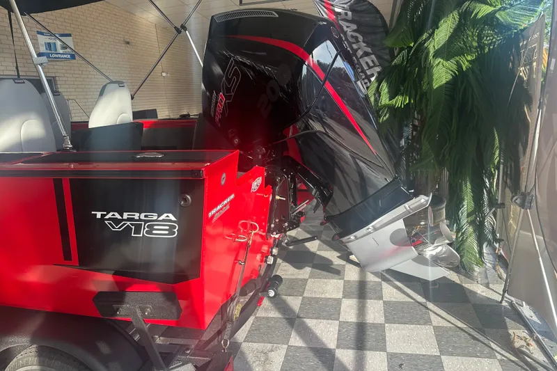 Slide: The Image of 2027 Tracker Targa V-18 Combo boat with powerful outboard motor, displayed indoors. - 14
