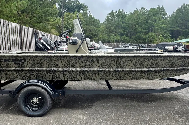 The Image of 2027 Tracker Grizzly 1860 CC boat on trailer, camo design, parked outdoors. - 0