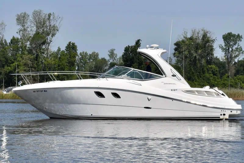 Slide: The Image of 2008 Sea Ray Sundancer 310 yacht cruising on a calm lake with lush green trees. - 5