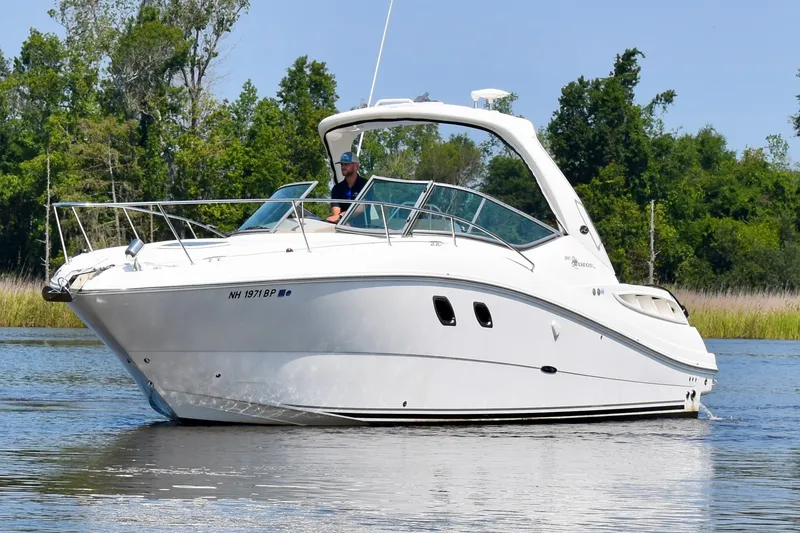 Slide: The Image of 2008 Sea Ray Sundancer 310 cruising on a calm lake with lush green trees. - 3