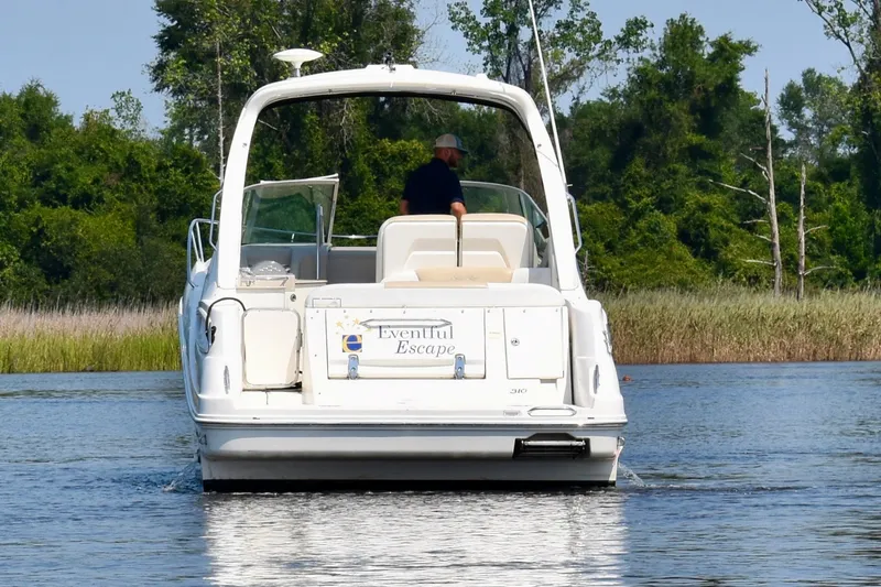 Slide: The Image of 2008 Sea Ray Sundancer 310 cruising on a serene lake with lush greenery. - 6