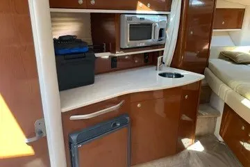 Slide: The Image of 2008 Sea Ray Sundancer 310 interior with kitchenette, microwave, and compact fridge. - 12