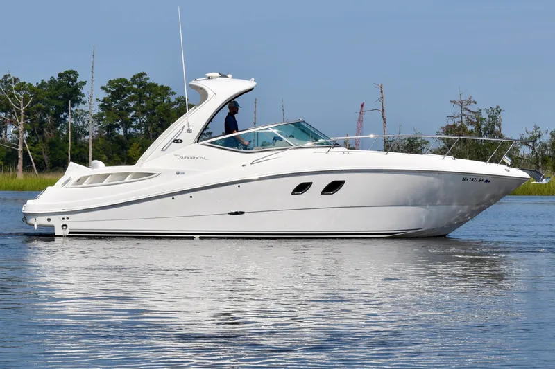 Slide: The Image of 2008 Sea Ray Sundancer 310 cruising on a calm lake with trees in the background. - 2